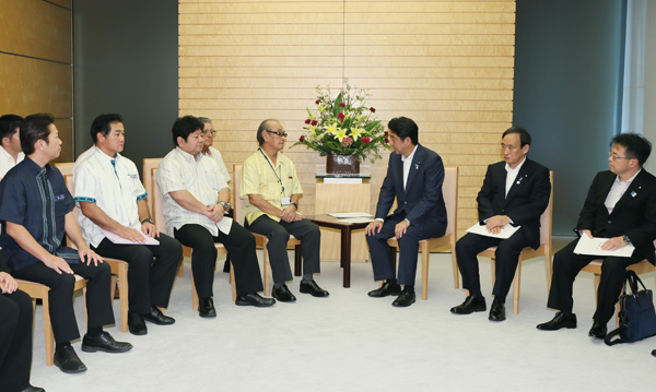 安倍总理在总理大臣官邸接受了来自冲绳县促进军用地转用与基地问题协议会的要求。