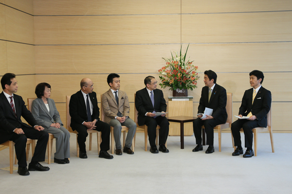 安倍总理在总理大臣官邸接收了故乡建设有识之士会议主席小田切德美递交的报告书。