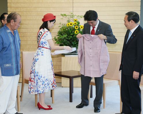 安倍总理在总理大臣官邸接受了冲绳县知事仲井真弘多赠送的“嘉利吉衬衣”。