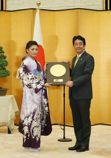 安倍总理在总理大臣官邸为伊调馨女士举行了国民荣誉奖表彰仪式，并颁发了奖状、奖牌及纪念品。