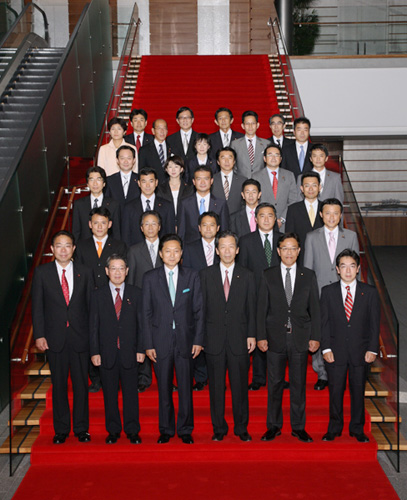 大臣政務官とともに記念写真に臨む鳩山総理の写真