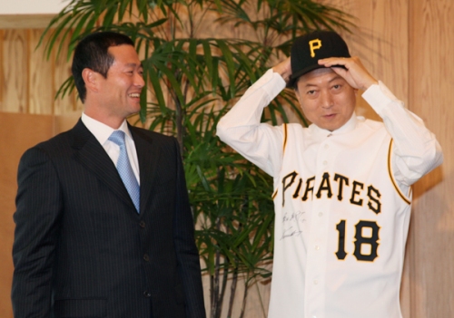 桑田氏よりユニフォームと帽子を贈呈される鳩山総理の写真