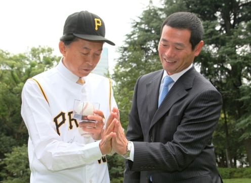 総理大臣官邸の庭で桑田氏と手のひらの大きさを比べる鳩山総理の写真