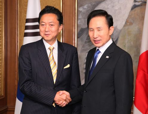 日韓首脳会談で李明博大統領と握手する鳩山総理の写真