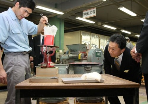 工場で調色工程の説明を受ける鳩山総理の写真