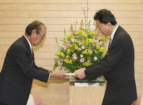 仲井真弘多沖縄県知事から要望書を受け取る鳩山総理の写真