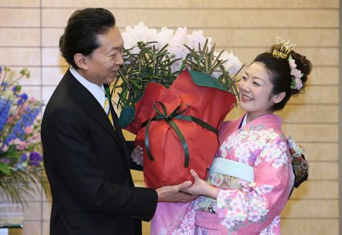 さくらの女王からシャクナゲの贈呈を受ける鳩山総理の写真