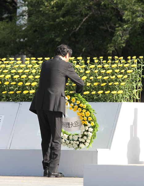 平和祈念式で献花をする菅総理の写真