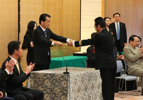 防災功労者内閣総理大臣表彰式で表彰状を授与する菅総理の写真
