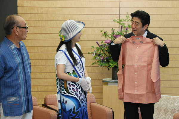 安倍总理在总理大臣官邸接受了冲绳县知事仲井真弘多赠送的“嘉利吉衬衣”。