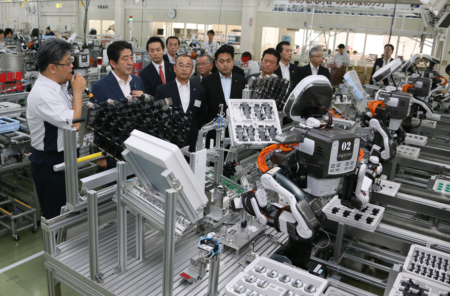 安倍总理视察了应用机器人的工厂和护理设施。
