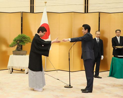 安倍总理在总理大臣官邸为羽生善治先生及井山裕太先生举行了国民荣誉奖表彰仪式，并颁发了奖状、奖牌及纪念品。