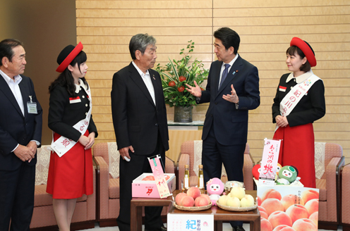 安倍总理在总理大臣官邸接受了和歌山县纪之川市市长中村慎司等赠送的桃子。