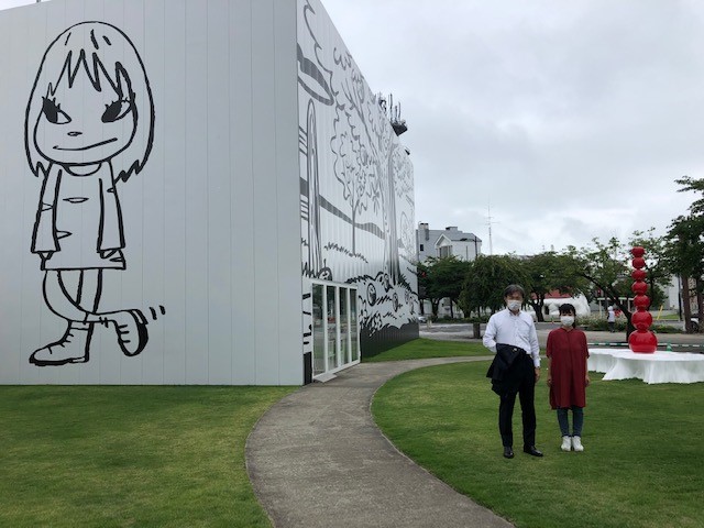 奈良美智氏のアート作品「夜露死苦ガール2012」。右は、学芸員の見留さん（東京都出身）この絵を目当てに美術館を訪れる若い人も多い。