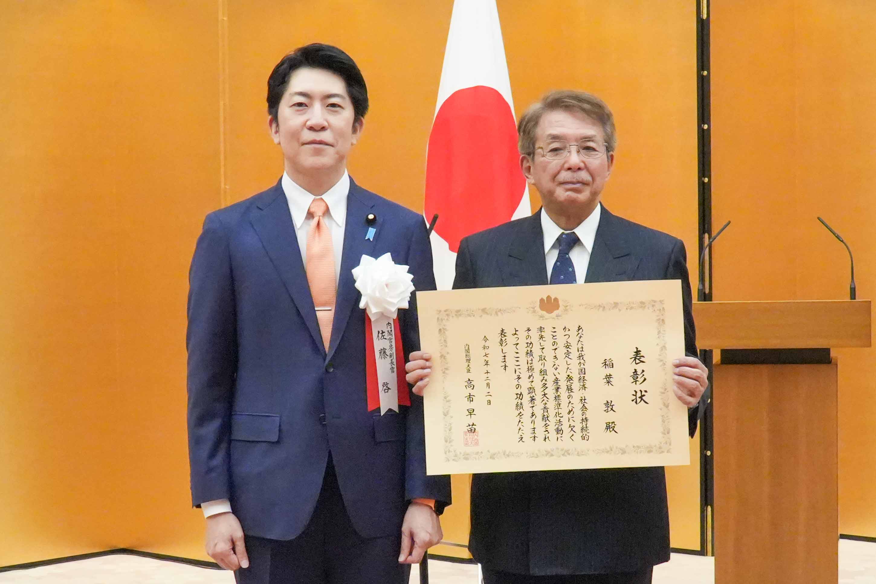 賞を授与する佐藤官房副長官２