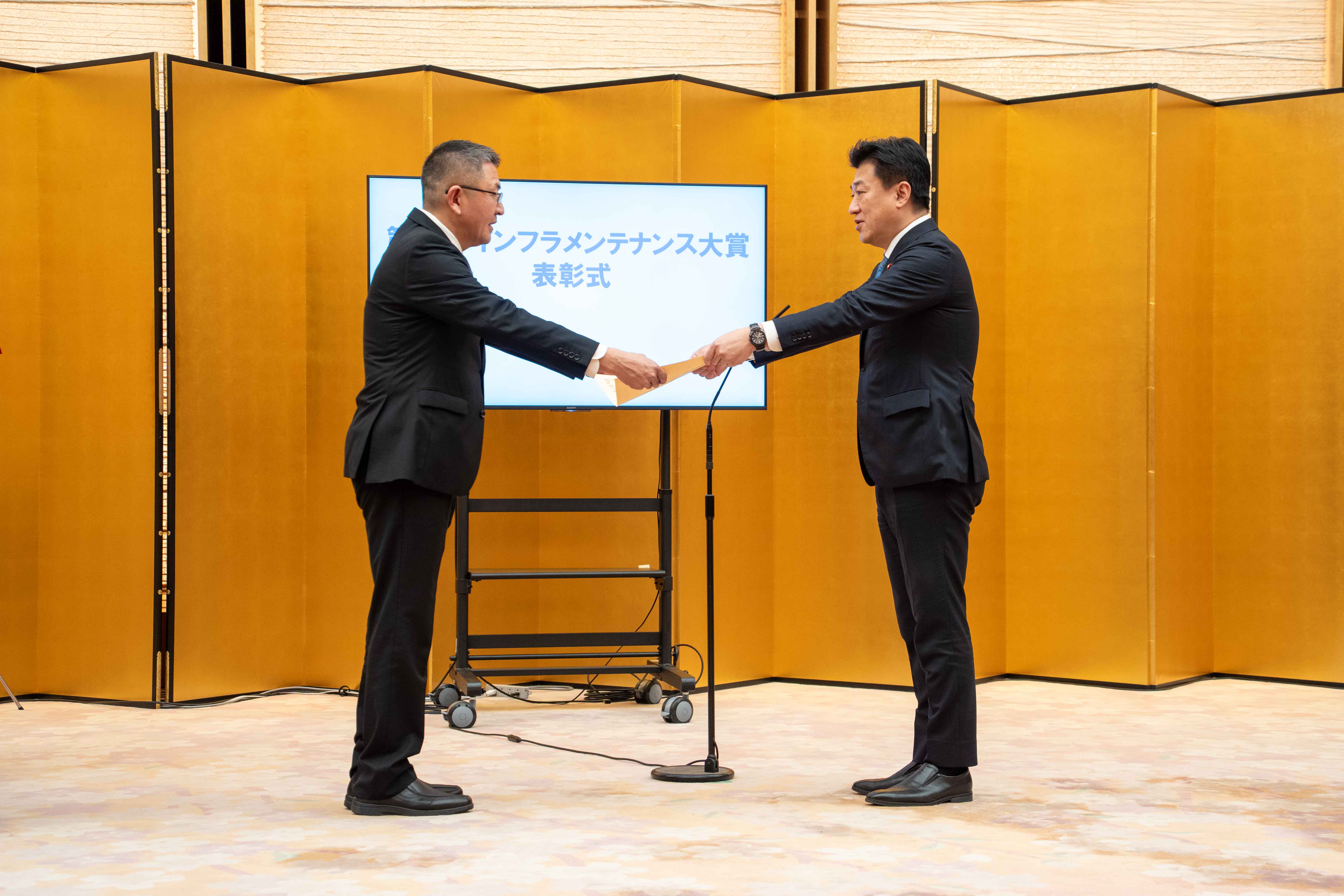 表彰状を授与する木原官房長官