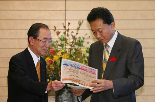 第３次勧告を見る鳩山総理の写真