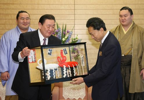 武蔵川理事長から横綱のミニチュアの贈呈を受ける鳩山総理の写真