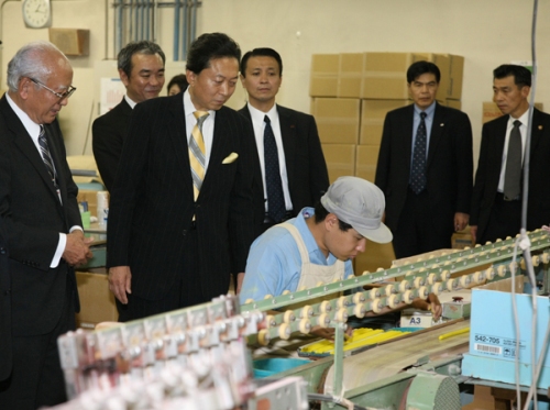 工場の製造ラインを視察する鳩山総理の写真１