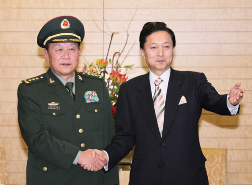 梁光烈国務委員兼国防部長と握手する鳩山総理の写真