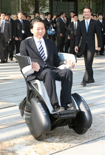デモンストレーションで電気自動車に試乗する鳩山総理の写真