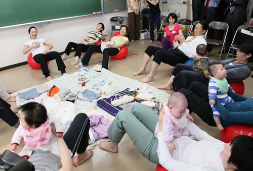 産後女性と一緒に腹筋を鍛える鳩山総理の写真