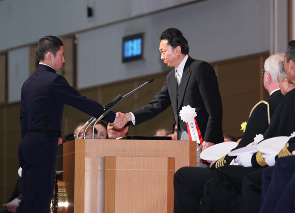 一般幹部候補生の宣誓を受け、握手する鳩山総理の写真　