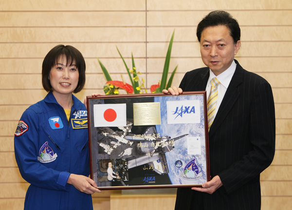 山崎宇宙飛行士から記念品の贈呈を受ける鳩山総理の写真