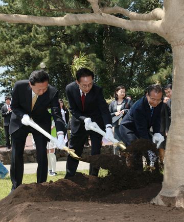 日中韓少年タイム・カプセル埋設式で記念植樹を行う鳩山総理の写真