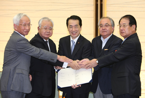 仕事と生活の調和推進官民トップ会談において握手を交わす菅総理の写真