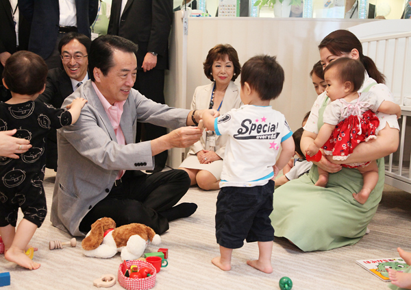事業所内保育所で子供とふれあう菅総理の写真