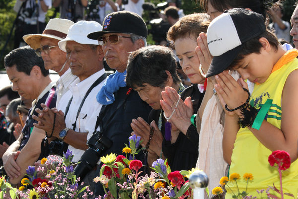 平和祈念式で黙とうする参列者の写真