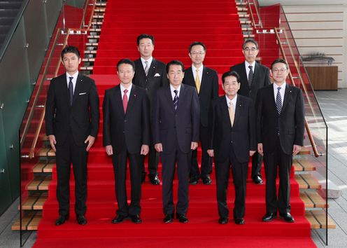 総理補佐官との記念撮影に臨む菅総理の写真