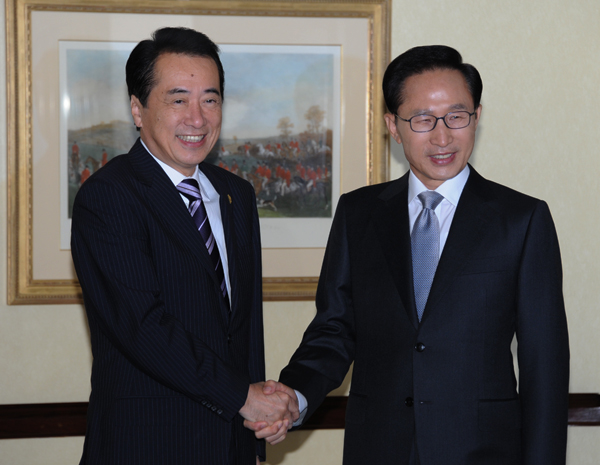 大韓民国の李明博大統領と握手する菅総理の写真