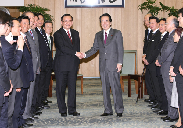 新日中友好２１世紀委員会中国側座長の唐家セン委員と握手する菅総理