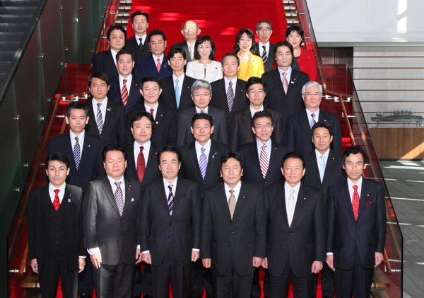 大臣政務官とともに記念写真に臨む菅総理の写真